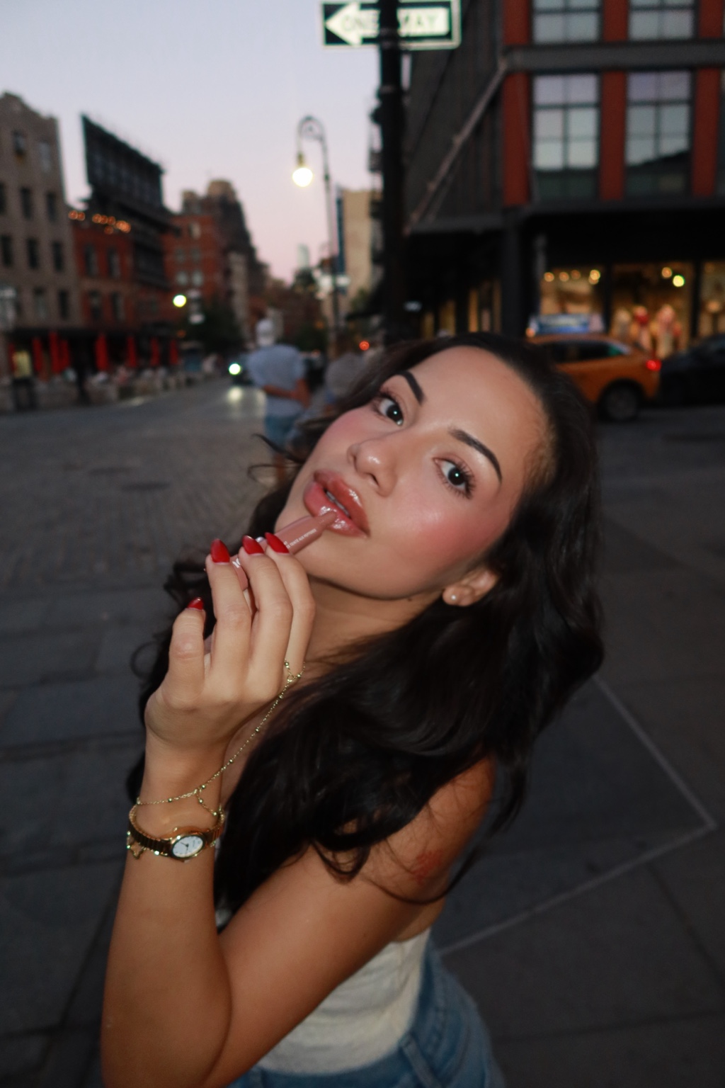 Jessica applying lip liner on a New York City street